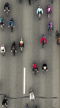 Large group of diverse cyclists riding together on an asphalt road during a city marathon, embodying concepts of community, sustainable transport, and collective movement