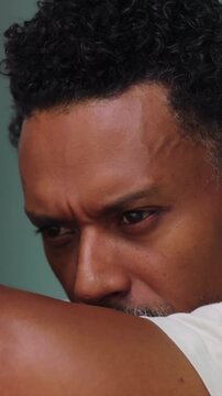 Close-up of African American man resting head on arms in deep contemplation
