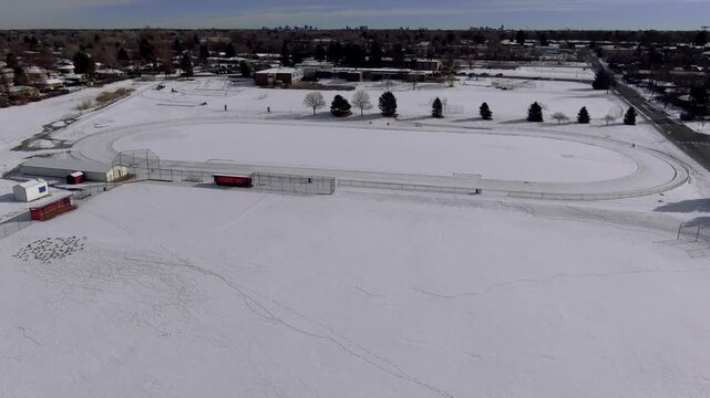 Aerial view of a red bus driving through a snow covered field in winter.