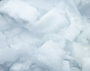 Abstract winter background with ice crystals and snow chunks for seasonal design. © IULIIA