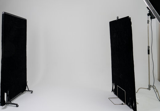 Professional Photography Studio with Black Light Absorbing Panels and Lighting Equipment on Seamless White Background