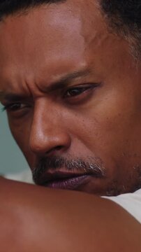 African American man leaning on arms with thoughtful expression in deep introspection