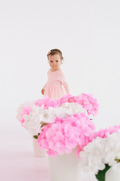 Small Girl Standing behind Pink Hydrangea Bouquets