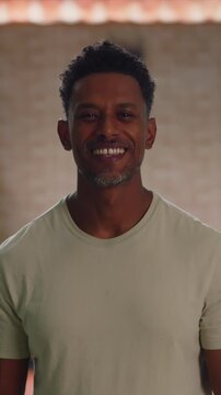 African American man standing indoors with warm smile and confident, approachable expression