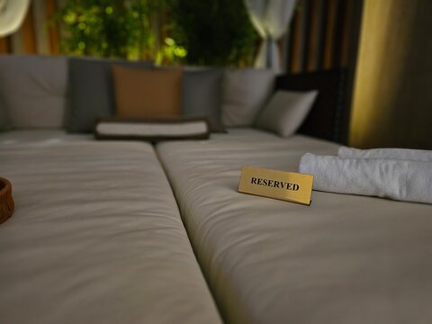 Reserved sign on a bed in a cozy setting prepared for guests at a luxury resort in the evening concept