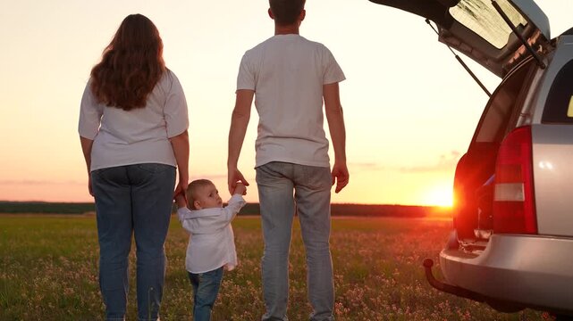 Happy family with kid son enjoying nature in field sunset sky. Mother father, baby son, car trip, family vacation trip. Mom dad, little boy travel by car, picnic nature. Parents child, unity, outdoors