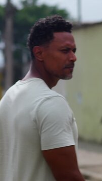 African American man walking away from camera on urban street in calm reflective mood