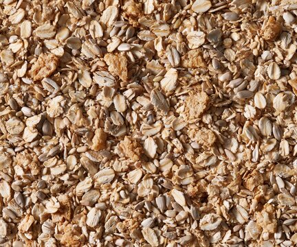 Grain and oats mixed with seeds and toasted clusters, showing a tactile crunchy texture for healthy food backgrounds and packaging layouts