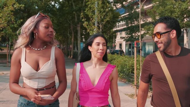 Diverse group of young professional friends walking and talking together in the city