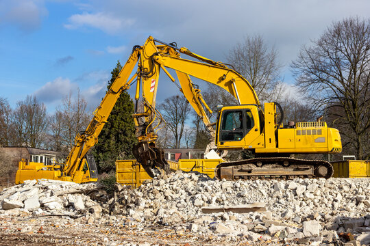 Heavy crawler excavator on rubble carrying out demolition work at a construction site.