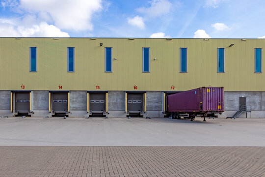 Row of loading docks with shutter doors at an industrial warehouse, used for freight handling and logistics operations.