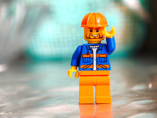 Fototapeta premium Russia, St. Petersburg, August 8, 2020 A detailed view of a Lego minifigure wearing a hard hat, great for construction or DIY projects