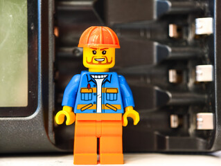 Fototapeta premium Russia, St. Petersburg, August 8, 2020 A close-up of a Lego man wearing a hard hat, perfect for illustrations and designs