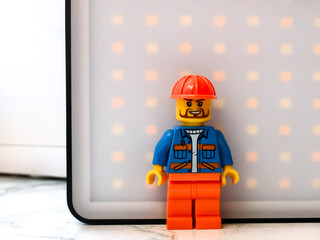 Fototapeta premium Russia, St. Petersburg, August 8, 2020. Lego man sitting in front of a LED panel, great for creative projects and illustrations.