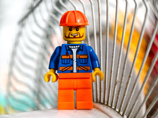 Fototapeta premium Russia, St. Petersburg, August 8, 2020 A close-up of a Lego man wearing a hard hat, perfect for illustration or design use