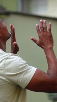 African American man raising hands in triumphant praise, gratitude, and deep spiritual connection