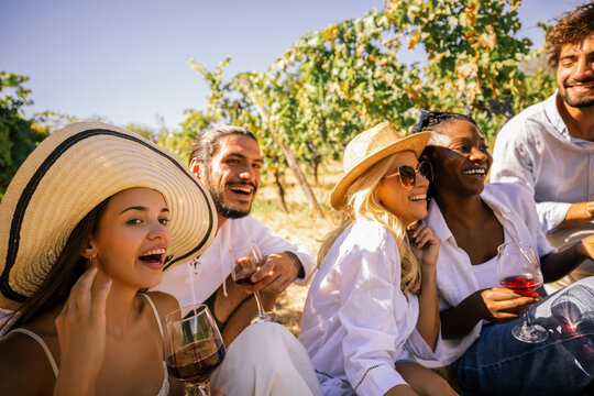 Group of friends enjoying wine and laughter in a vineyard