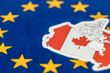 Fototapeta na wymiar Canada as an associate member of the European Union. Business concept. EU flag and Canadian symbol. Copy space, close-up.