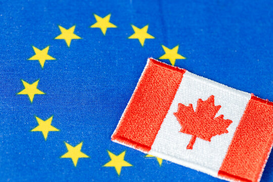 Canada as an associate member of the European Union. Business concept. EU flag and Canadian symbol. Copy space, close up.