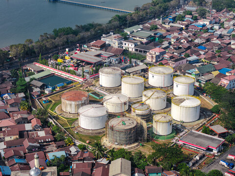 Aerial view of PT. Pertamina TBBM Samarinda fuel storage tanks surrounded by dense residential housing and urban infrastructure in Samarinda, East Kalimantan, Indonesia.