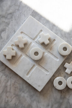 overhead shot of marble tic tac toe game on marble surface 