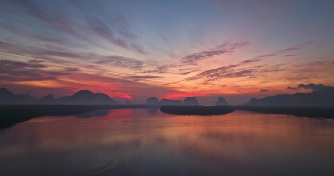 Aerial view of scenery sky reflection at Ban Sam Chong fishing village at twilight. Reflection of the dusk sky in a fishing village living, isolated island surrounded by mangrove forests.