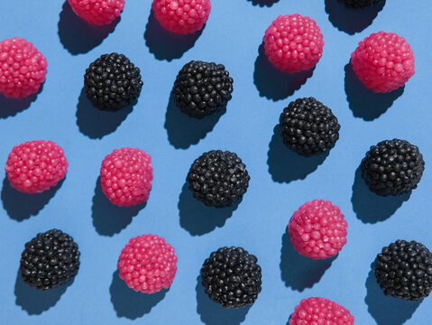 Assorted gummy candies shaped like berries top view on blue background