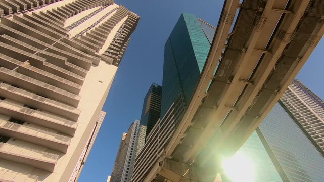raveling underneath a Miami bridge, with downtown buildings visible in the afternoon