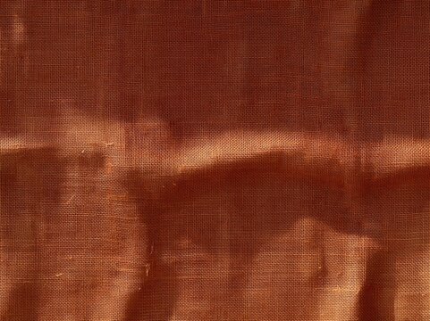 Burlap jute fabric texture with a coarse woven surface in terracotta and ochre tones, rustic and rough for natural backgrounds