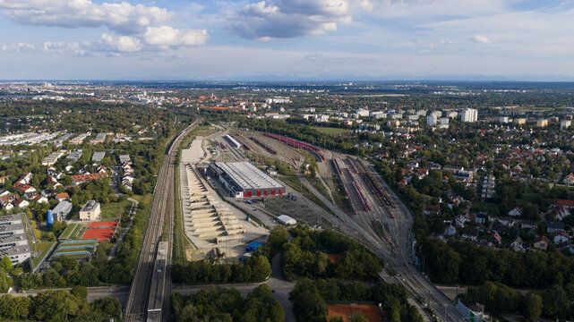 Aerial view of Bahnbetriebswerk Munchen-Pasing train depot with extensive railway tracks, maintenance buildings, and surrounding urban landscape in Munich, Bavaria, Germany.