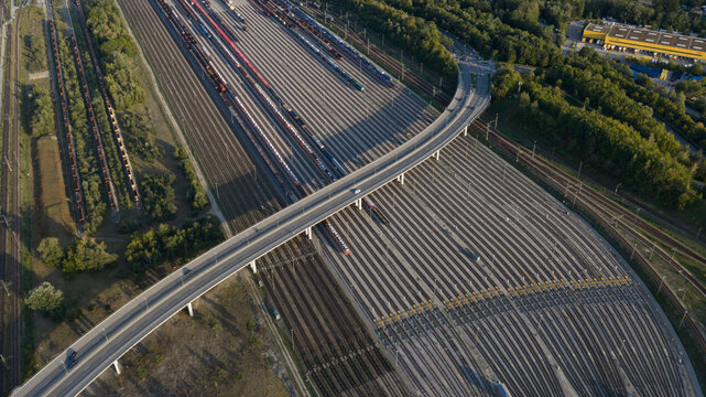 Aerial view of the Dachauer Brucke spanning over a large railway marshalling yard with numerous parallel tracks and freight trains in Munchen, Bayern, Germany.