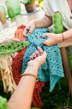 Women hands examining handmade crochet textile craft