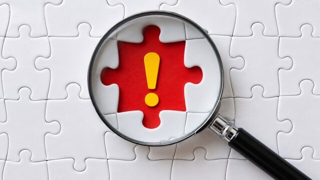 Magnifying Glass Focusing On Yellow Exclamation Mark In White Jigsaw Puzzle, Metaphor For Risk Assessment And Problem Detection
