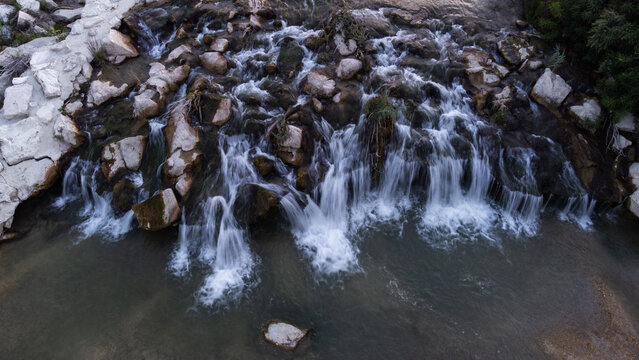Aerial view of the cascading waters of the Lungo Tenna river flowing over rocky terrain in Lungo Tenna, Marche, Italy.