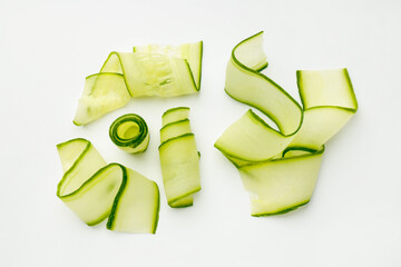 Obraz premium Slices of ripe cucumber on white background, flat lay