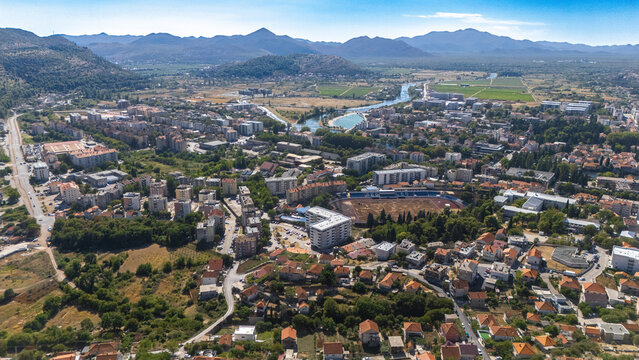 Aerial view of Trebinje city with its dense urban layout, residential buildings, a stadium, and the Trebisnjica river in Trebinje, Republika Srpska, Bosnia and Herzegovina.
