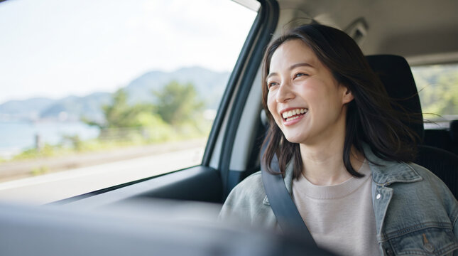 車でドライブを楽しみながら笑顔を見せる若い女性