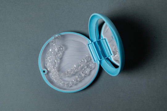 Clear aligners in blue orthodontic case with mirror