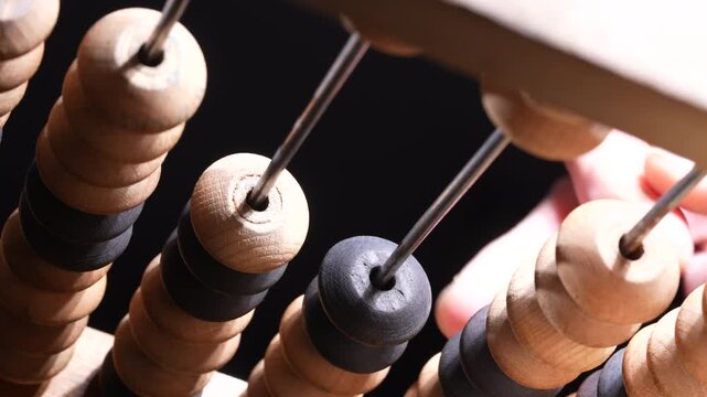 Macro view of vintage wooden abacus beads on rods representing counting calculation education finance and business accounting concept
