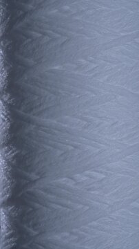 Close up of white polypropylene string wound sediment filter cartridge used for water purification filtration and household plumbing systems, rotates. Texture or background polypropylene water filter