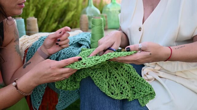 Women hands examining handmade crochet textile craft,  video 4k real time
