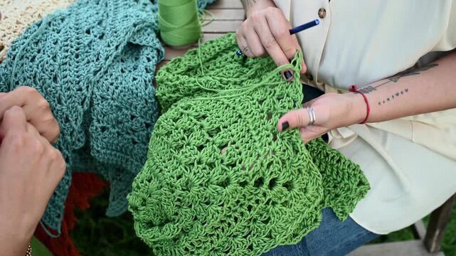 Women hands examining handmade crochet textile craft,  video 4k real time