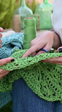 Women hands crocheting textile craft learning workshop outdoors