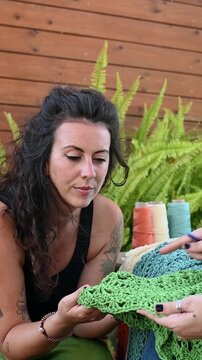 Women artisan friends discussing crochet craft and yarn