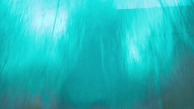  background with a wide cascade of clear, blue water flowing forcefully over a sheet of glass 