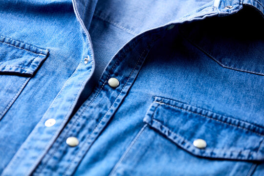 Close up of blue denim shirt with buttons. Soft focus.
