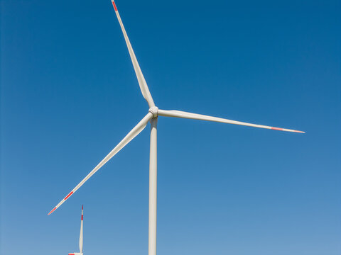 Aerial view of a white wind turbine against a clear blue sky in the Buch district of Berlin, Berlin, Germany.