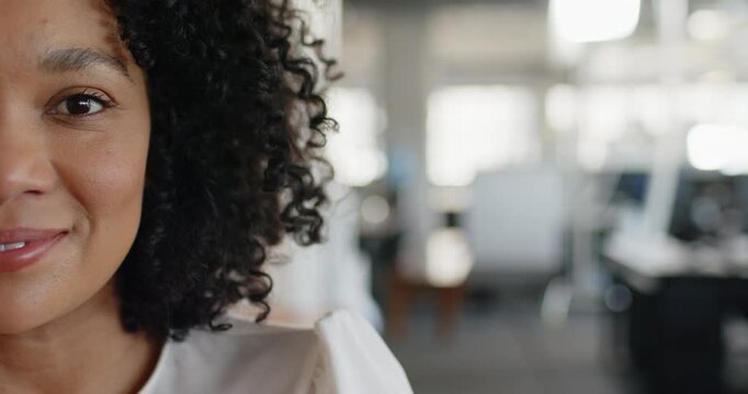 African American woman reacting to offscreen cue, smiling laughing at office with screen