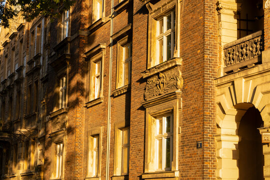 A section of the eclectic fa&ccedil;ade of a historic red-brick tenement house in Krak&oacute;w. Traditional Krak&oacute;w residential architecture from the turn of the 19th and 20th centuries.