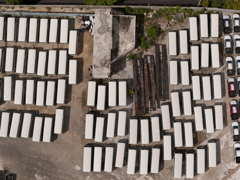 Aerial view of a large parking lot filled with rows of white buses and vans parked in an organized manner near Avenida Isabel Aguiar in Santo Domingo, Distrito Nacional, Dominican Republic.